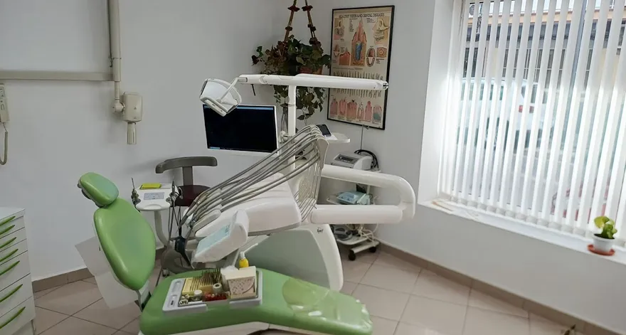 Sala de tratamiento con sillón clínico y póster anatómico